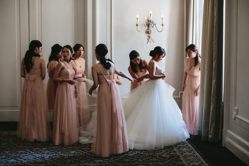bride gets dressed with her bridesmaids in blush pink dresses in the georgian room of the vancouver club www.lucida-photography.com
