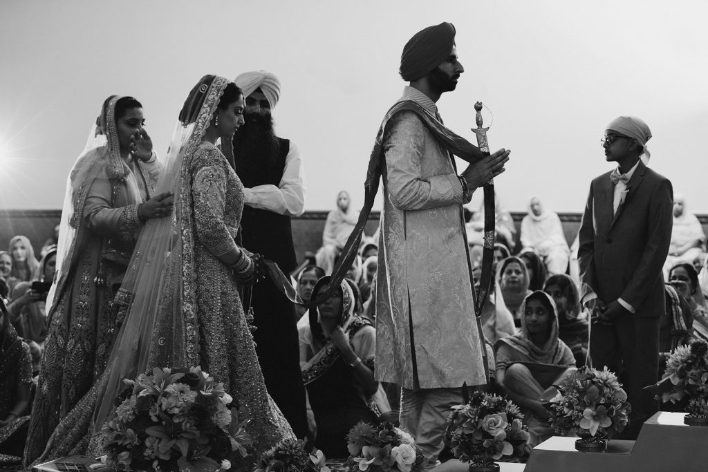 an Indian bride and groom walk around the Guru Granth Sahib during their Sikh wedding ceremony in Vancouver www.lucida-photography.com