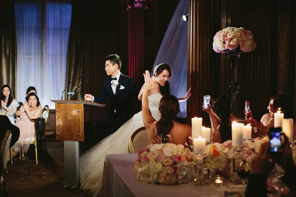 a bride high fives the head table at her vancouver club wedding www.lucida-photography.com